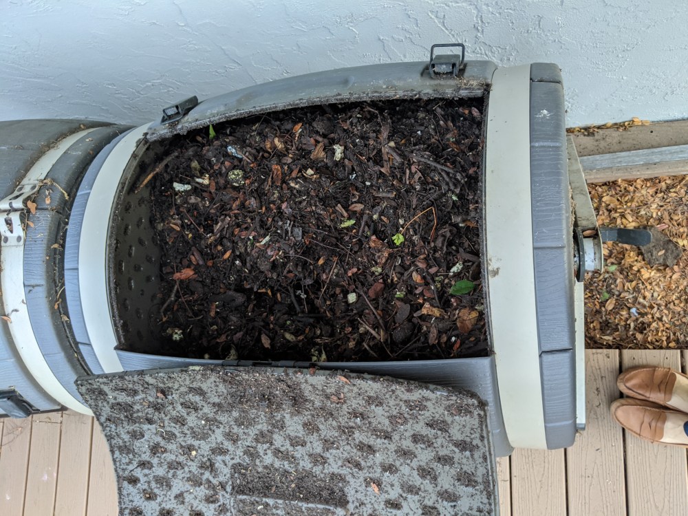 A nearly full compost tumbler with mostly finished compost.